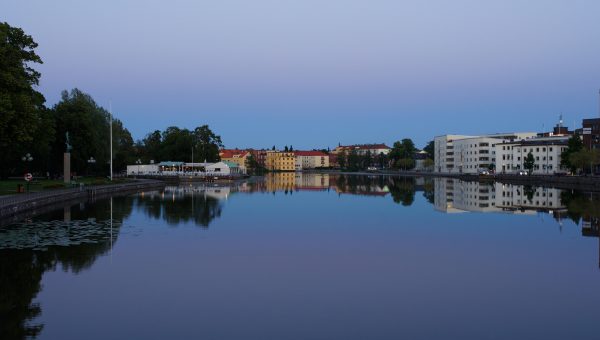 Vattendrag med byggnader i bakgrunden.