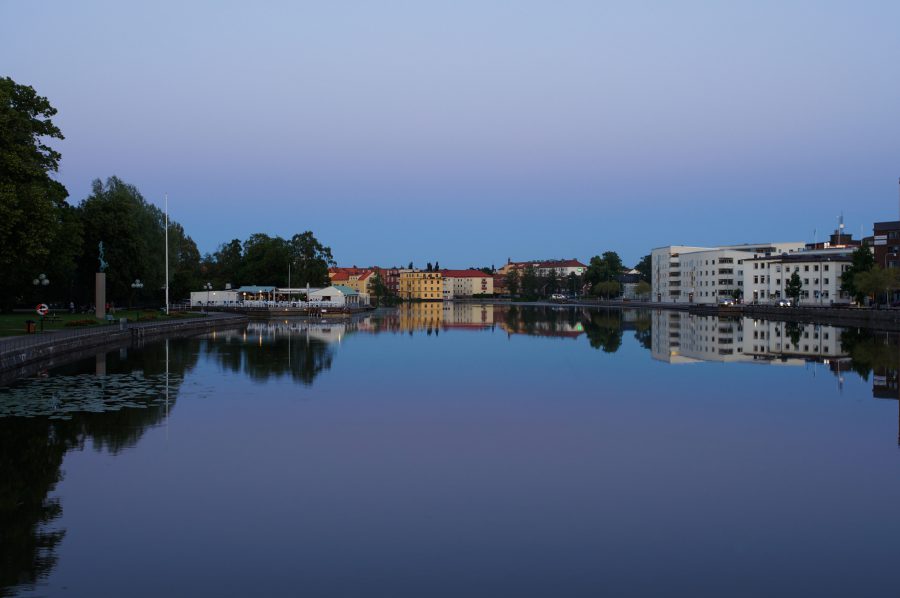 Vattendrag med byggnader i bakgrunden.