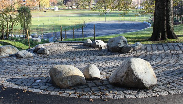 Stora stenar som placerats ut på kullersten i en park