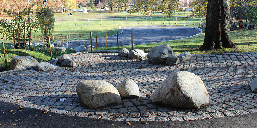 Stora stenar som placerats ut på kullersten i en park