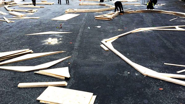 Plankor som ligger på en asfalterad plan i olika mönster