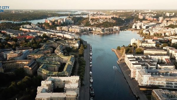 Ett flyg foto över en stad, vatten delar av mellan husen