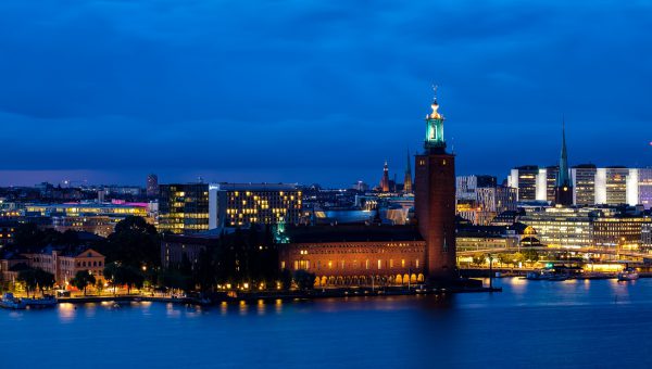 Vy av en stad i natten, ljuset reflekteras i vatten