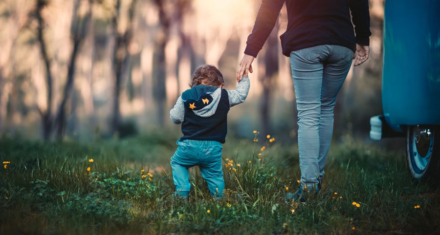 En mamma och ett barn går i en skog