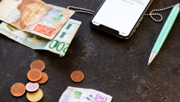 Utlysningar och finansiering. Mynt och sedlar, en smartphone