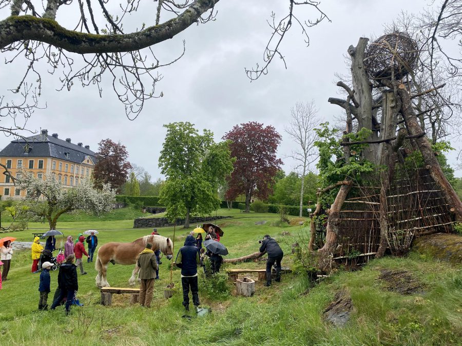 Människor som arbetar på en äng intill ett slott. 