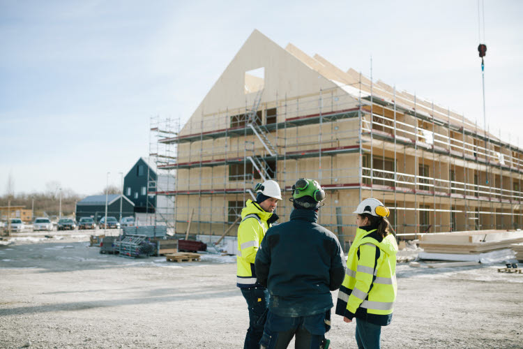 Hur hanterar kommunerna klimatdeklarationer? Bild på bygge med byggnadsarbetare.