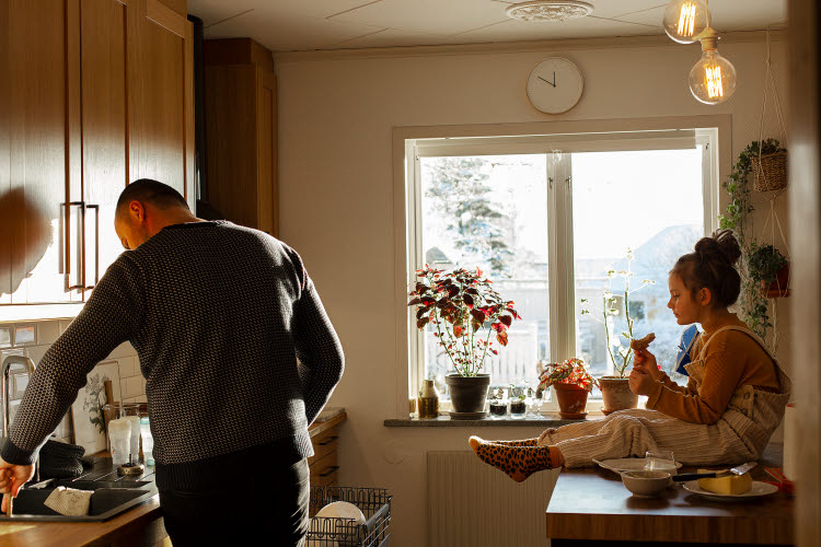 God inomhusmiljö i bostäder - bättre folkhälsa. Foto på man och barn i ett kök där barnet äter.