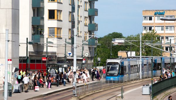 Transportsystemets energi- och klimatomställning. Foto på människor vid spårvagnsstation i Stockholm.