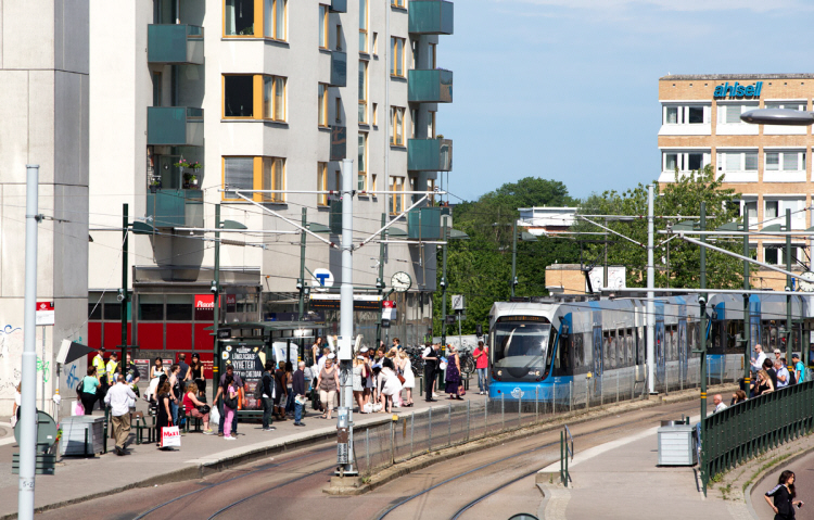 Transportsystemets energi- och klimatomställning. Foto på människor vid spårvagnsstation i Stockholm.
