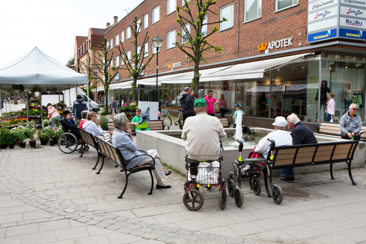 Utformning av fysisk miljö för alla. Människor sitter vid ett utecafé, ett torg utanför Stockholm