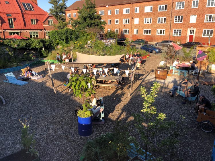 VInnovativ hållbar stadsutveckling. Innegård med bänkar, trädgårdar och hus