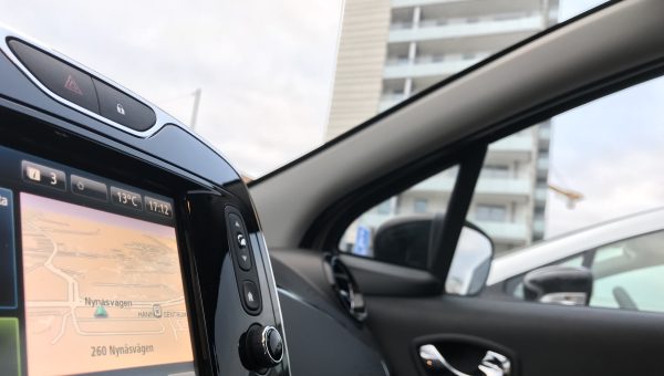 Bilden visar interiör för en av elbilarna som ingår i bilpoolen i Brf Blicken i Haninge. I bakgrunden ses bostadshuset.