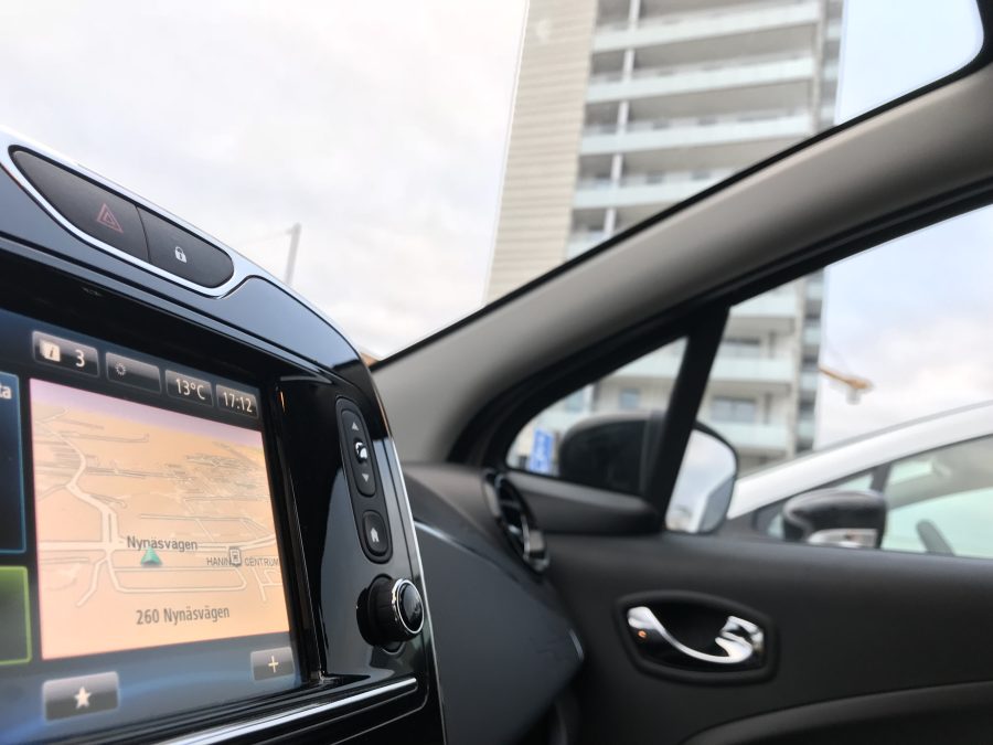 Bilden visar interiör för en av elbilarna som ingår i bilpoolen i Brf Blicken i Haninge. I bakgrunden ses bostadshuset.