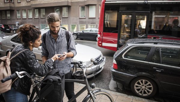 Ungt par med cyklar söker info i telefon