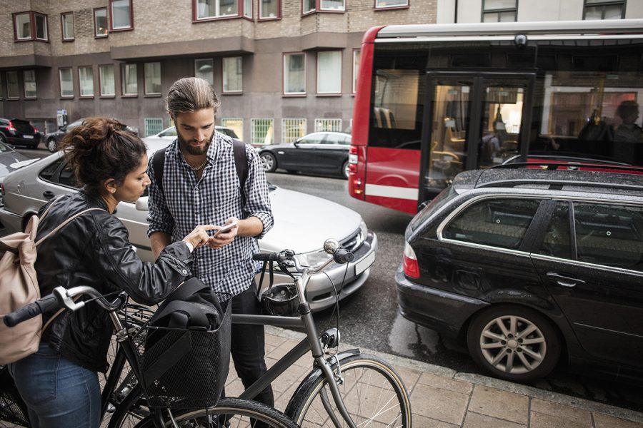 Ungt par med cyklar söker info i telefon